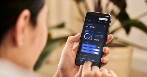En person håller i en mobiltelefon där Kameos app används.